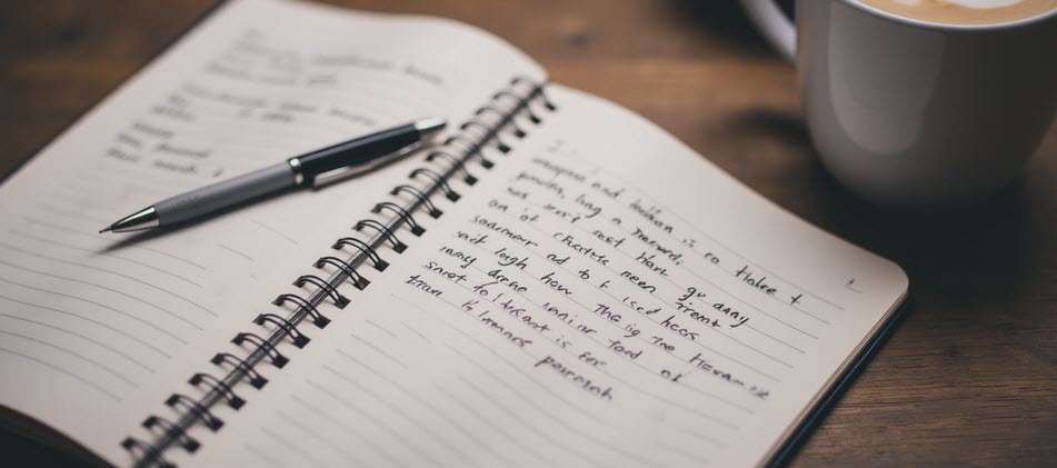 A journal open to reflective prompts beside a warm drink, inviting the viewer to pause and ask deeper questions about purpose.